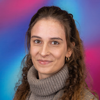 Headshot person with long curly light brown hair in marl rollneck