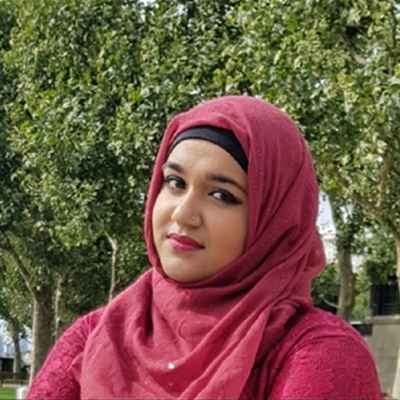 A person wearing a pink hijab looks at the camera