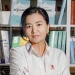 A person wearing a white shirt stands in front of library books