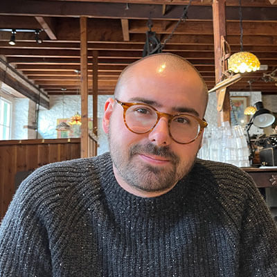 Caucasian man wearing glasses and a knitted jumper