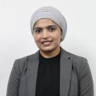 Smiling woman with a covered head and grey blazer