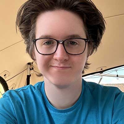 A student wearing their blue Student Ambassador t-shirt takes a selfie