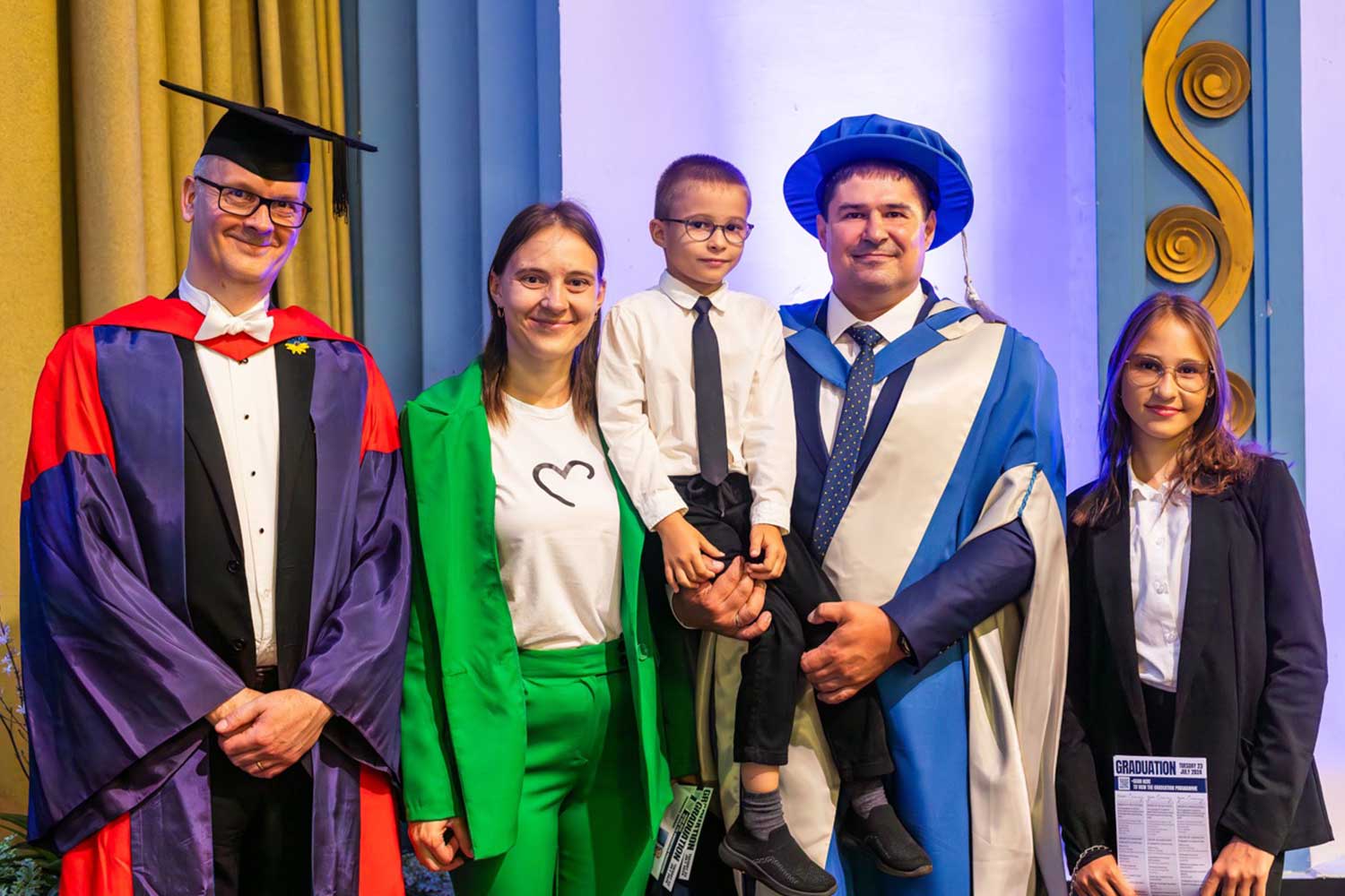 Professor Ian Gadd stands alongside Konstantin Kyrychenko and his family at graduation