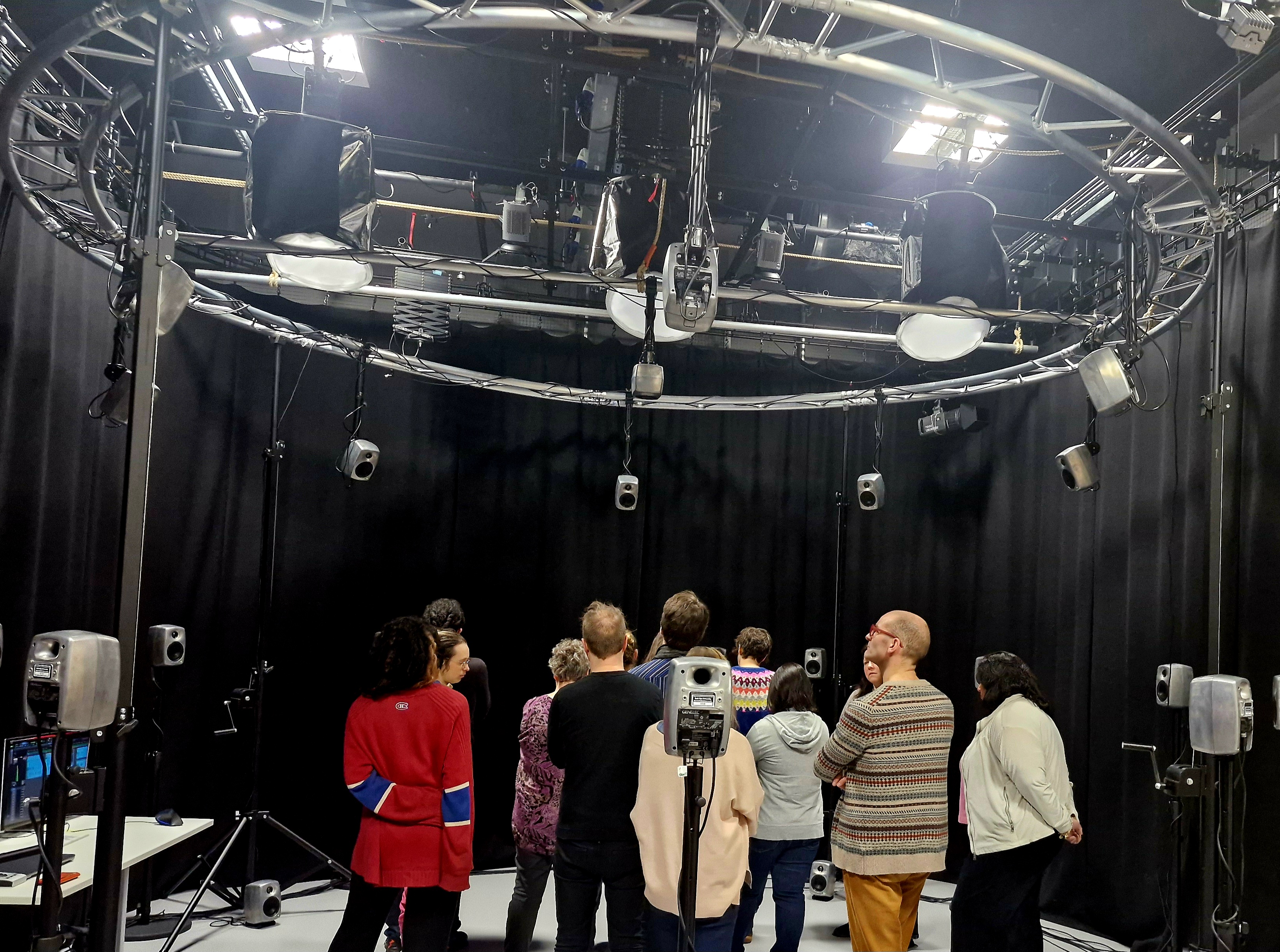 A group of people stand in an audio visual recording studio