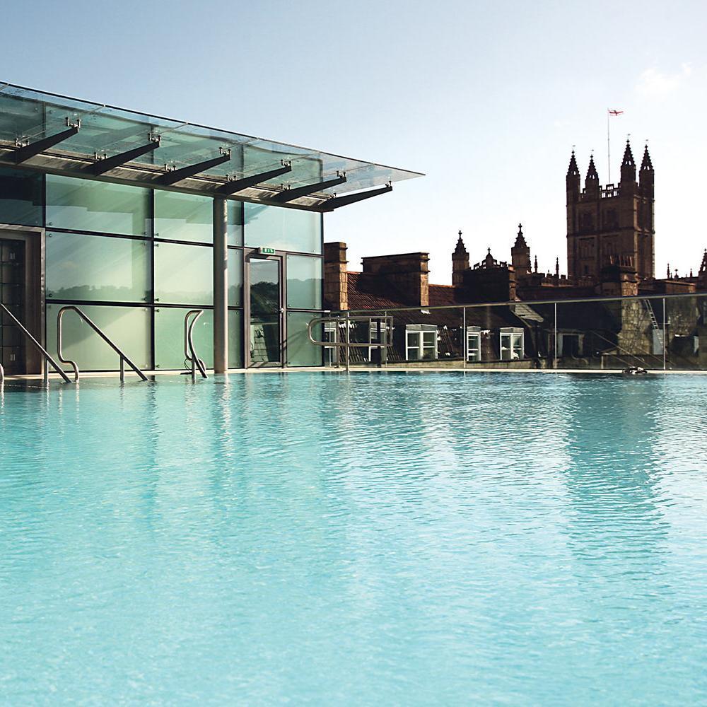 Light turquoise water rooftop pool with historic buildings in background