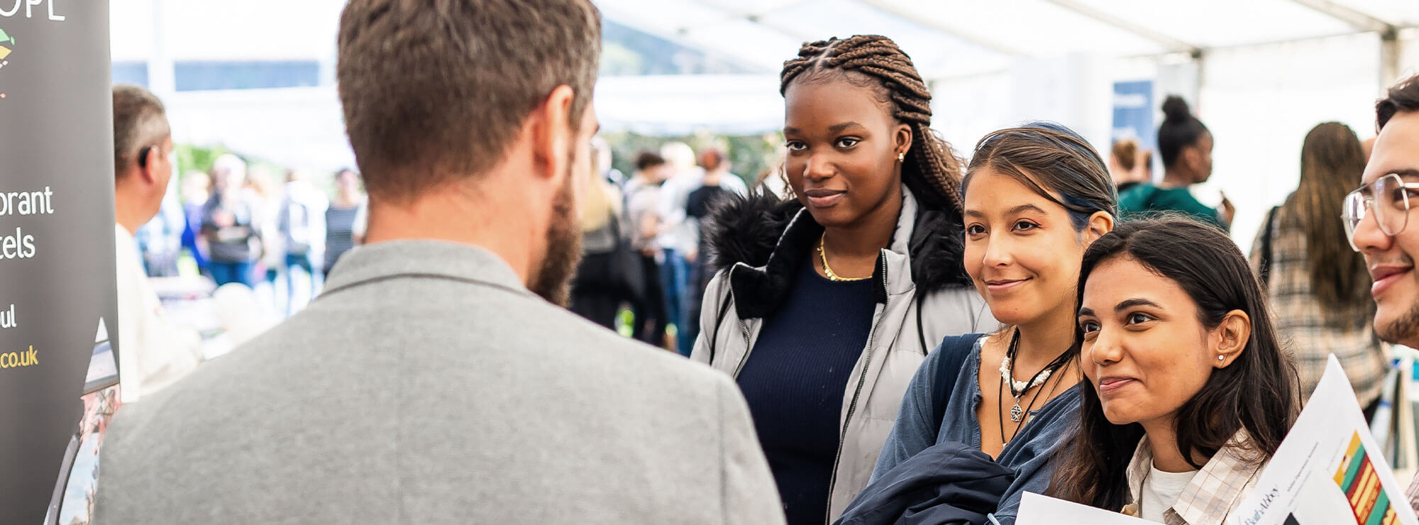 Group of students chatting an employer at a jobs fair