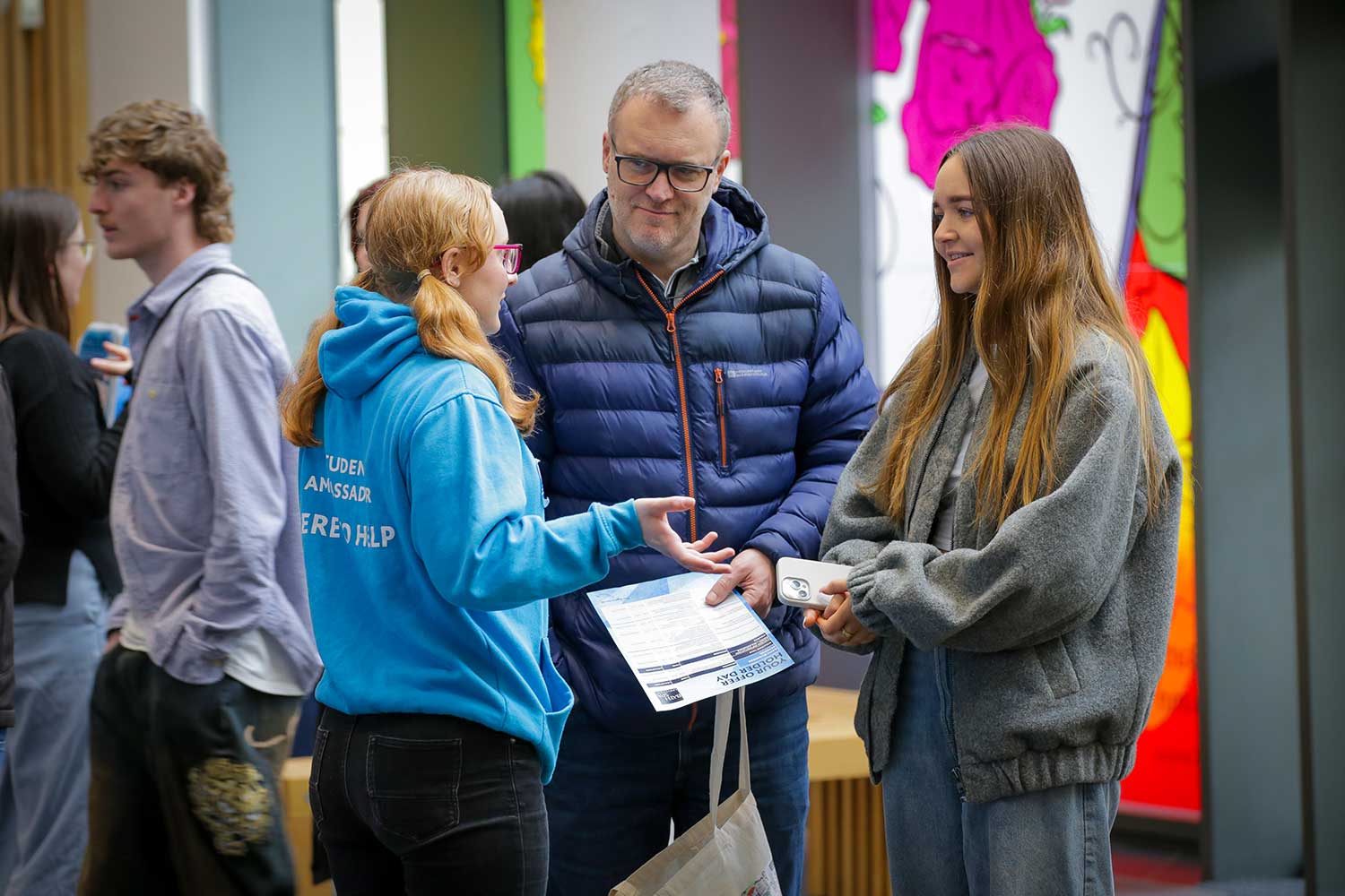 A Student Ambassador talks to two visitors at an Open Day