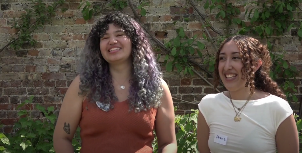 Two exchange students stand smiling and laughing