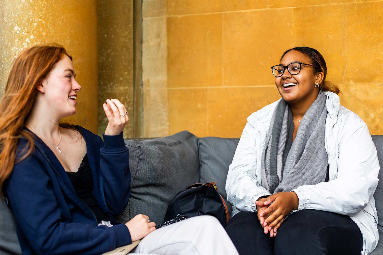 Two young people sitting outside laughing